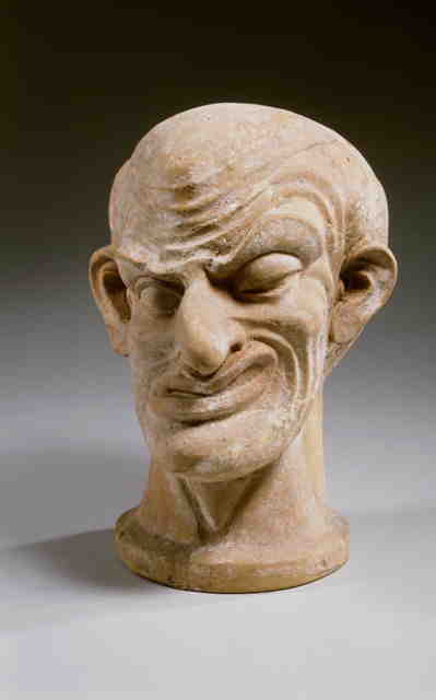 Stone sculpture of male head with distortions representing a hemifacial spasm